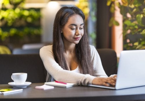 Pretty intelligent girl studying or working in cafeteria alone
