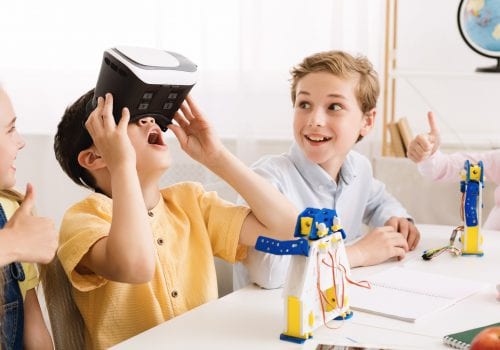 Schoolboy playing with vr glasses in classroom