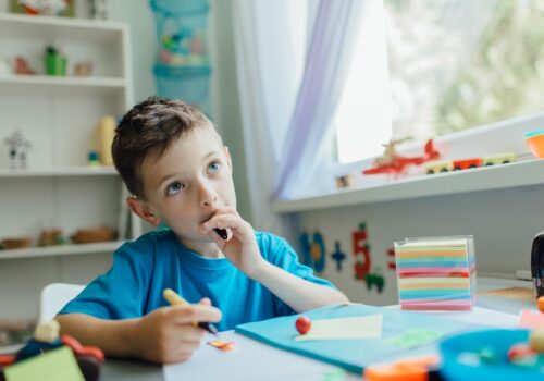 Thinking student doing his homework at home